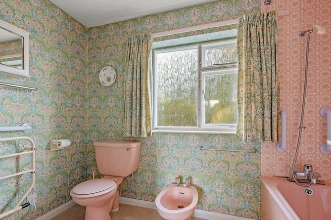 Original bathroom including green and pink bathroom tiles and wallpaper of the 1970s house in Salcombe, Devon. See SWNS story SWLNhouse. An incredible 'time warp' 1970s home with original patterned wallpaper, lino and apricot tiles has gone on the market - for Â£1million. The four bedroom property was originally built in the seventies and has been with the same owners for almost 40 years. The house is described as being "ready for modernisation" but some 70s fans may want to leave the decor exactly as it is.