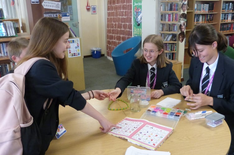 Erin Powell, Elsie Harding and Eleni Kitidis making bracelets for the Craft Club