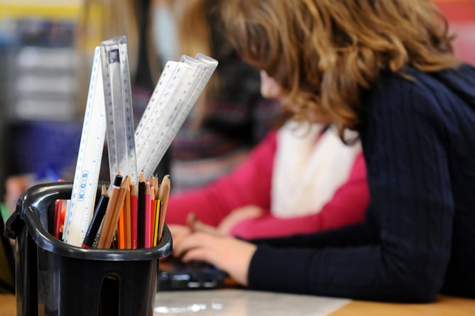 A generic stock photo shows Primary School children at work in a classroom.