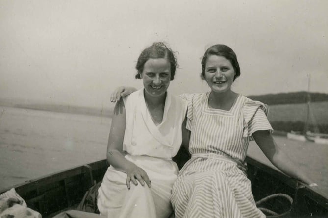 Postcard showing two ladies in a small boat. Titled 'Cedar? right fishing out of Hallsands 1933'