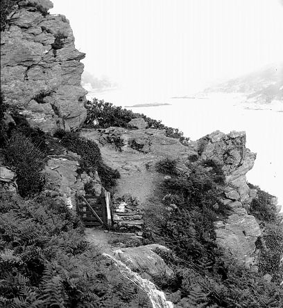 'Pathway to Bolt Head'. Looking back up the estuary, with the Blackstone etc. dimly seen in background. 
Gate in foreground. Yellow paint on plate forms waterfall-shaped mark in foreground.