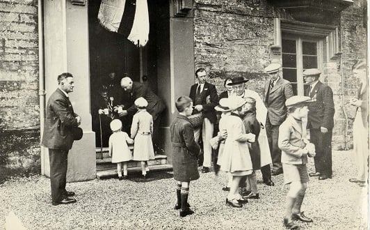 Vicar of Aveton Gifford greeting children on occasion of Silver Jubilee 1935.   
Children being given commemorative mugs. 