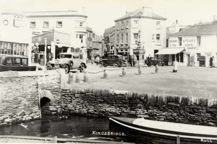 Head of Kingsbridge estuary (c1930), walls and granite bollards.  
Note presence of drinking fountain at road junction.  
Ryeford Garage on left.  Stone bollards removed every year for the fair.