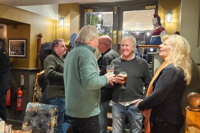 Salcombe Mayor Cllr Mark Goodey joins RNLI team members and others to toast the switch of The Field of Light