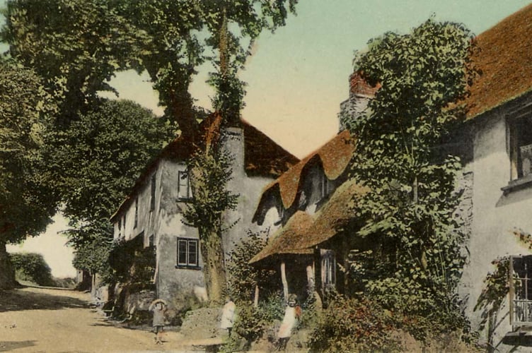 Thurlestone main street with children outside cottages. At top of village looking up hill.  